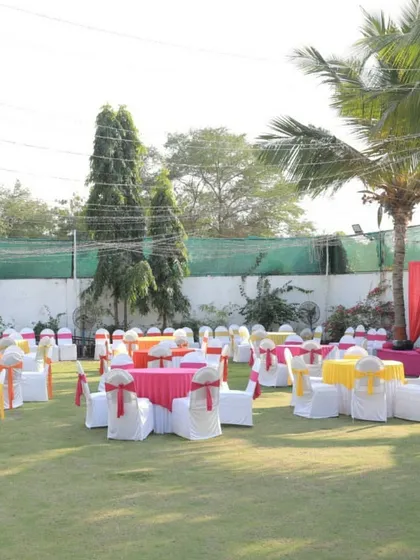 A bright and cheerful seating arrangement for a Mehendi ceremony on a lawn. We used a vibrant color scheme of pink, yellow, and orange for the tablecloths and chair sashes to create a festive atmosphere.