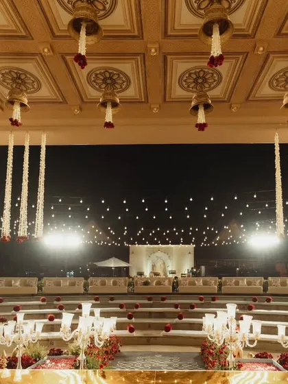 A view from the amphitheater seating, looking towards the magnificent custom brass mandap. Every detail, from the intricately designed pillars to the cascading floral arrangements, was crafted to create a breathtaking and immersive wedding ceremony experience.