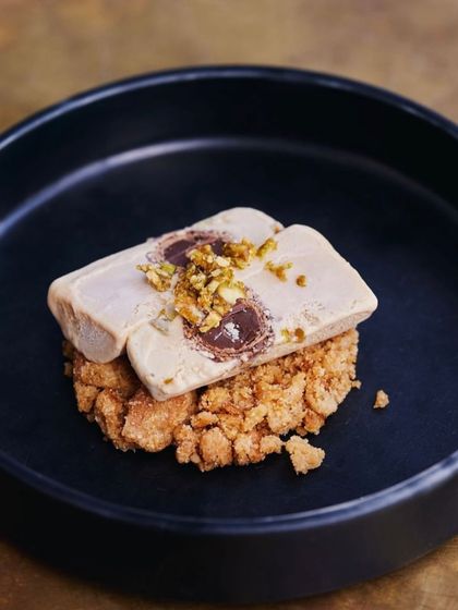The final presentation of our bestselling Salted Chikki Kulfi, featuring a Monaco biscuit crumble and a chocolate-filled center. It's a dessert that's as fun to eat as it is delicious.