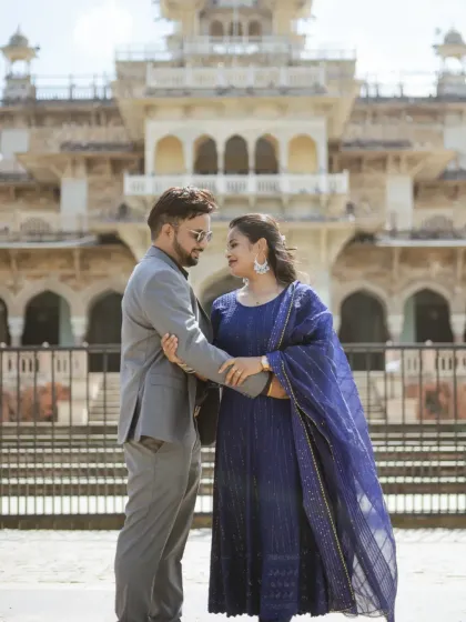 A sophisticated couple portrait in front of the Albert Hall Museum. The classic architecture and the couple's elegant blue outfits create a picture of timeless grace.