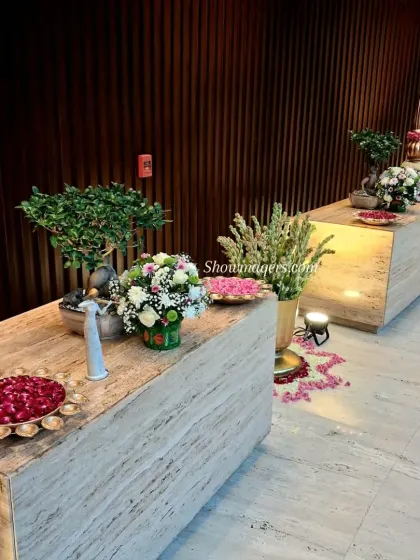 Elegant decor for a corporate celebration. We used marble-finish counters decorated with fresh flowers and traditional brass bowls filled with rose petals to create a sophisticated welcome area.