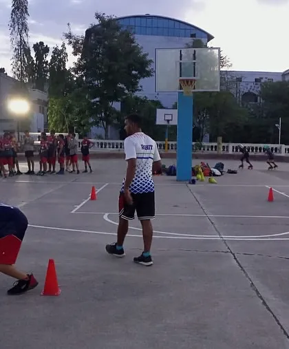 A wide shot of the training camp, with Coach Rohit overseeing drills and ensuring every player is engaged.