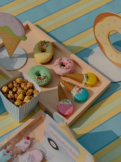 This tray from the ice cream party features pastel-colored donuts and macarons creatively topped with mini waffle cones and sprinkles.