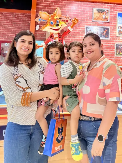 A family poses with our mascot after a fun day, holding a goodie bag from one of our special promotions.