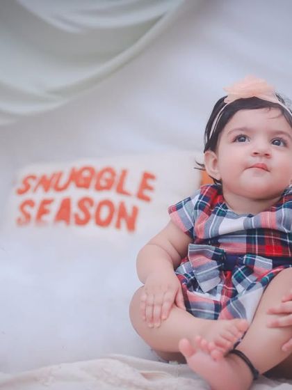 This little one is sitting among fluffy clouds, looking up curiously. Our themed shoots are designed to be both beautiful and engaging for children.