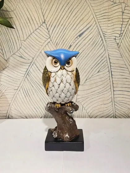 This owl showpiece features a bold blue cap, adding a pop of color.
