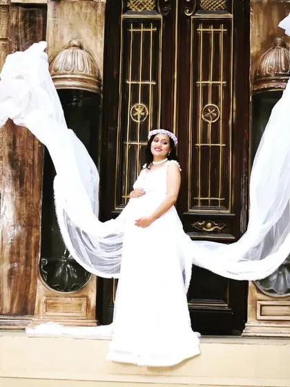 Creating magical moments is what we do best. This shot captures the elegance of our flowing white maternity gown, with the long train creating a stunning visual against the classic architecture.