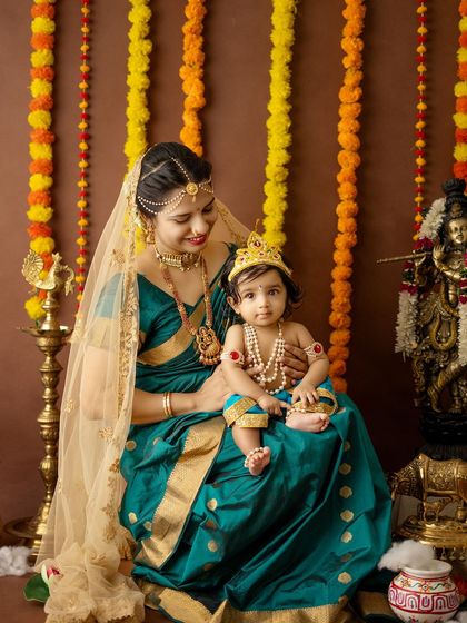 A detailed shot focusing on the traditional outfits and jewelry of both mother and child.