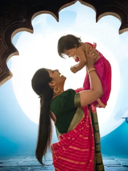 The joy of a mother lifting her child, framed within a traditional Indian archway. This backlit silhouette captures a dynamic and emotional moment during our Janmashtami mini sessions.