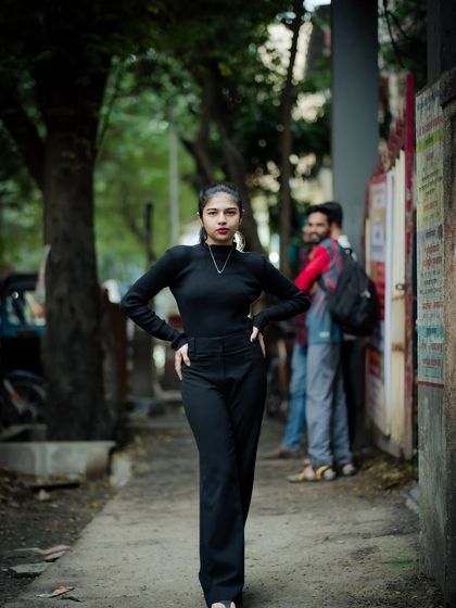 A powerful, full-length portrait on a quiet lane. The all-black outfit creates a strong, confident silhouette.