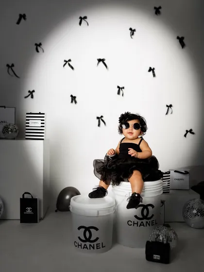 A spotlight shines on the baby sister, giving her a moment in the limelight during this incredibly fun and creative photoshoot.