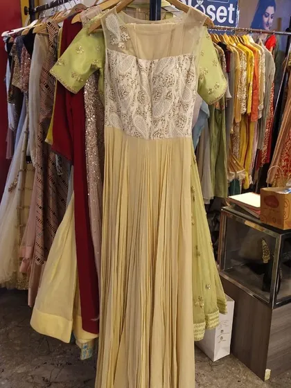A beautiful pale yellow gown with a sheer neckline and an embroidered paisley-patterned bodice. The pleated skirt adds texture and movement to this graceful and elegant dress.