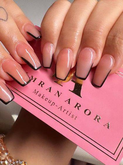 A different angle of the popular black-outlined French manicure, held against my business card.