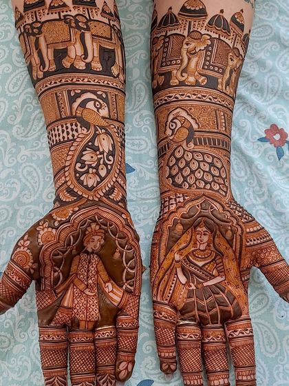 A classic depiction of a royal bride and groom, each on one palm, framed by intricate arches. The forearms continue the story with a wedding procession featuring decorated elephants.