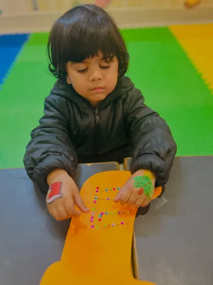 A little boy works on his stocking, showing the pride he takes in his work.