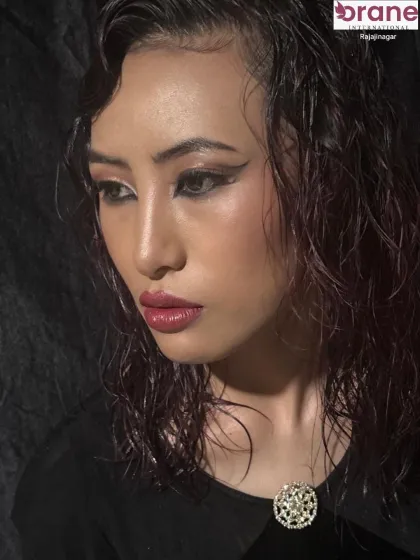 Another angle of the glossy, wet look, focusing on the sharp winged eyeliner and dewy skin finish. We teach the techniques needed to achieve these polished, professional results.