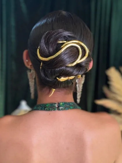 A detailed close-up of the snake accessory woven through the sleek bun, a key look from my masterclass.