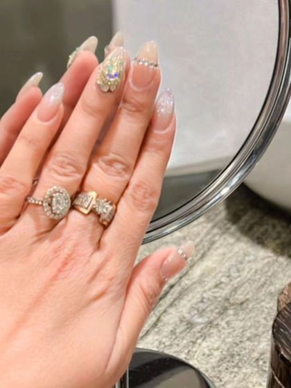 A mirror-reflected view of the glamorous crystal-accented nail set, showing off the sparkle and detail.