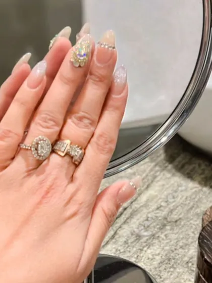 A mirror-reflected view of the glamorous crystal-accented nail set, showing off the sparkle and detail.
