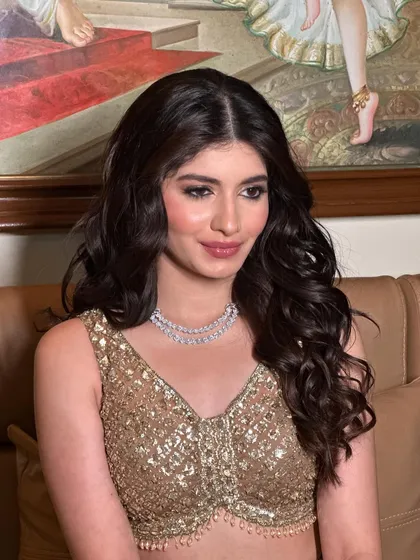 This shot captures the happy glow of a client who feels confident and beautiful. The open hairstyle with defined waves is perfect for a sangeet or cocktail event.