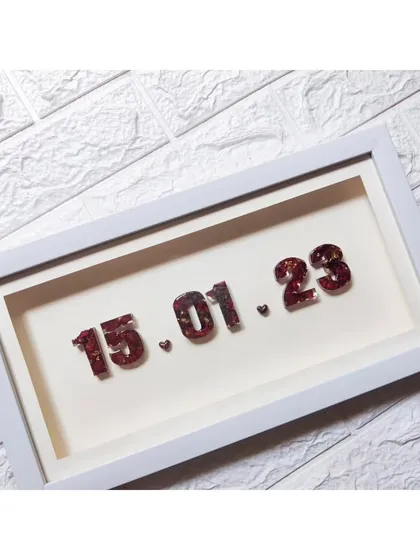 This minimal shadow box frame is a beautiful and budget friendly way to cherish your special date. The numbers are made with resin and preserved varmala flowers, creating a simple yet meaningful keepsake.