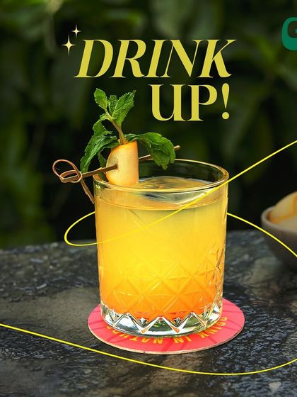 Drink up! This refreshing orange cocktail, garnished with mint, is perfect for a sunny afternoon.