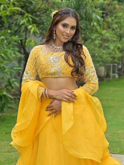 A three-quarter view of the yellow lehenga, showing the complete look from a different angle.