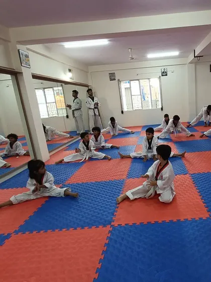Students at our Banaswadi dojang work on their splits, building the flexibility needed for advanced Taekwondo techniques.
