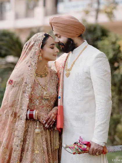An intimate portrait of Simranjeet and Bimaljeet, their foreheads touching in a moment of quiet connection during their wedding day.