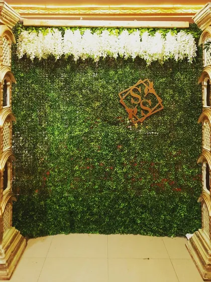 A baby shower mantap with a greenery backdrop and a custom monogram.