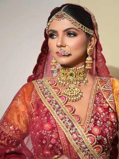 A three-quarter profile view that highlights the contour and glow on the cheekbones, as well as the rich colors of the bridal outfit.