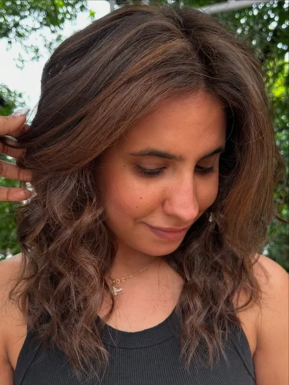 Holiday ready with these soft, beachy waves and subtle brunette highlights. This is a low-maintenance color that grows out beautifully, perfect for someone who travels a lot.