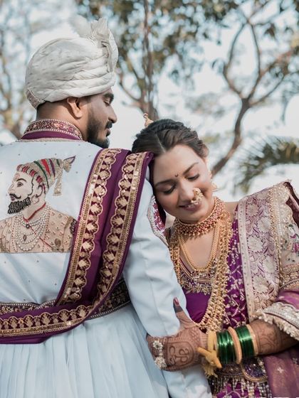 A tender moment between the royal couple. The groom's custom sherwani with a portrait of Shivaji Maharaj is a stunning tribute to Maharashtrian heritage.
