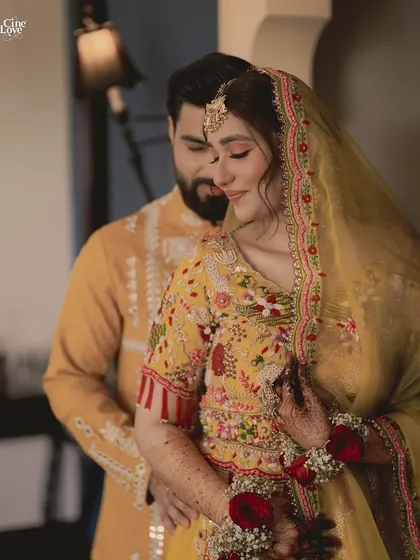 A close-up of the couple, showing the beautiful details of the bride's floral jewellery and the groom's embroidered kurta.