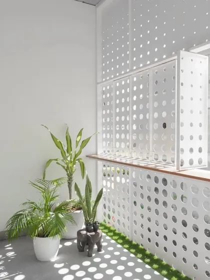 Inside the LUCID House, the perforated screen casts a dappled light effect onto the balcony floor and walls. This space becomes a canvas for the changing light, documenting the passage of time throughout the day.