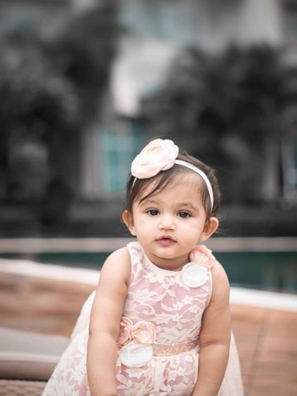 A quiet, thoughtful moment. Even when she's not giggling, this little one looks absolutely angelic in her custom-made dress. These are the moments to cherish.