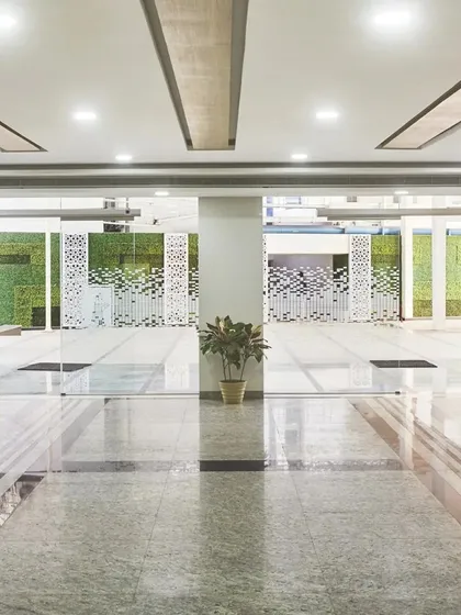 The entrance to the new expansion of Ramkrishna Care Hospital features a green wall and perforated screens. This contemporary design language evolves the aesthetic of the campus while prioritizing a connection to nature.