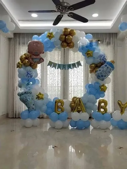 A 'BABY' themed decoration with a circular balloon arch in blue, white, and gold, perfect for a baby shower or welcome party.