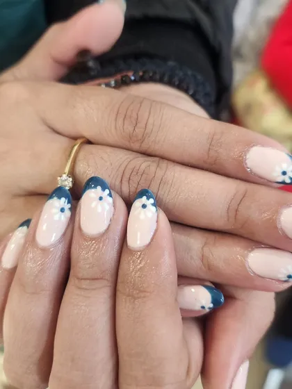 A lovely floral design on a French manicure base. I hand-painted small white daisies along the dark blue tips for a charming and fresh look.