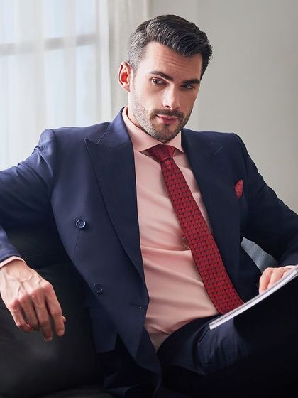 The double-breasted suit paired with a pink shirt and red tie creates a confident and stylish combination. This look is perfect for the man who isn't afraid to embrace color in his professional life.
