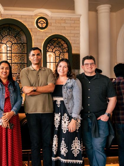 A group photo capturing the success of a corporate gathering. The grand arches and sophisticated bar area provide an impressive setting for team photos and memories.