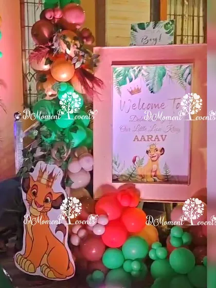 A welcome sign for "Our Little Lion King, Aarav," framed by themed balloons and a Simba cutout.