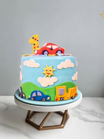 Vroom, vroom! A cheerful car-themed cake for a first birthday, featuring a sunny day and colorful vehicles. A perfect start to a life of adventure.