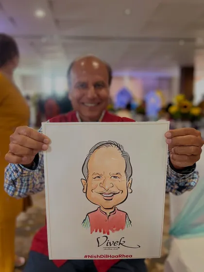A smiling guest proudly holding his caricature. These quick sketches become a great conversation starter and a fun memory of the event.