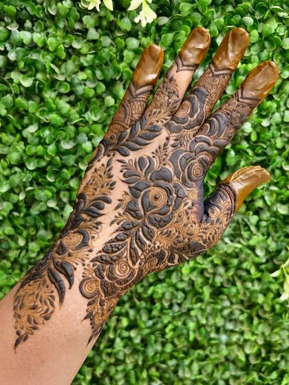 A bold and beautiful floral siders design, covering one side of the hand in a dramatic, flowing pattern.