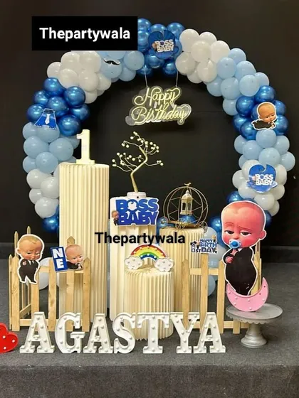 A cute Boss Baby setup with a ring balloon arch and character cutouts. The little red heart light adds a pop of color.
