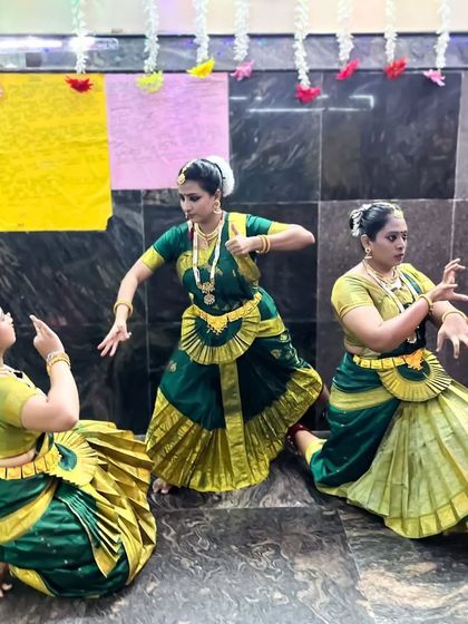 A trio of dancers in an interactive pose, showcasing the storytelling aspect of Bharatanatyam during their Navaratri performance.