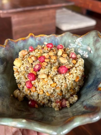 A healthy and vibrant grain salad made with barnyard millet (samak) and pomegranate, beautifully presented in a leaf-shaped bowl.