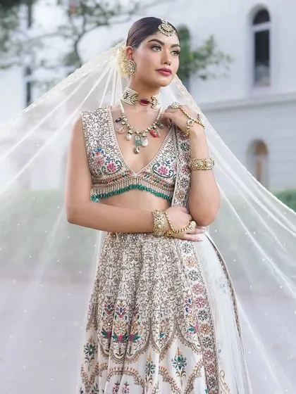 Presenting "Laila," a dreamy bridal look. I styled this ivory lehenga with multi-colored embroidery and a sheer veil for a whimsical and romantic feel.