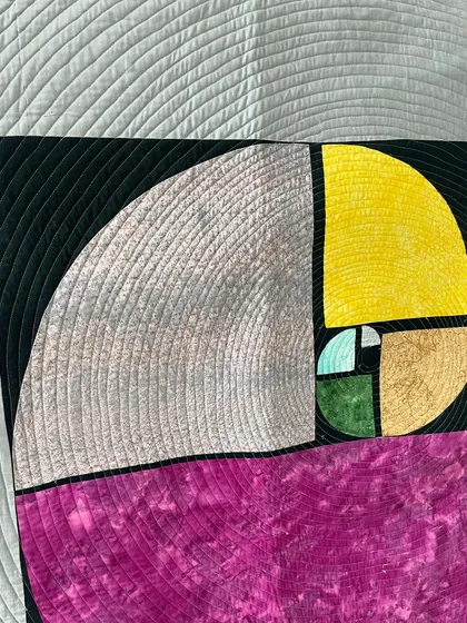A close-up of the Fibonacci spiral, where we used quarter-inch spiral quilting to echo the design.